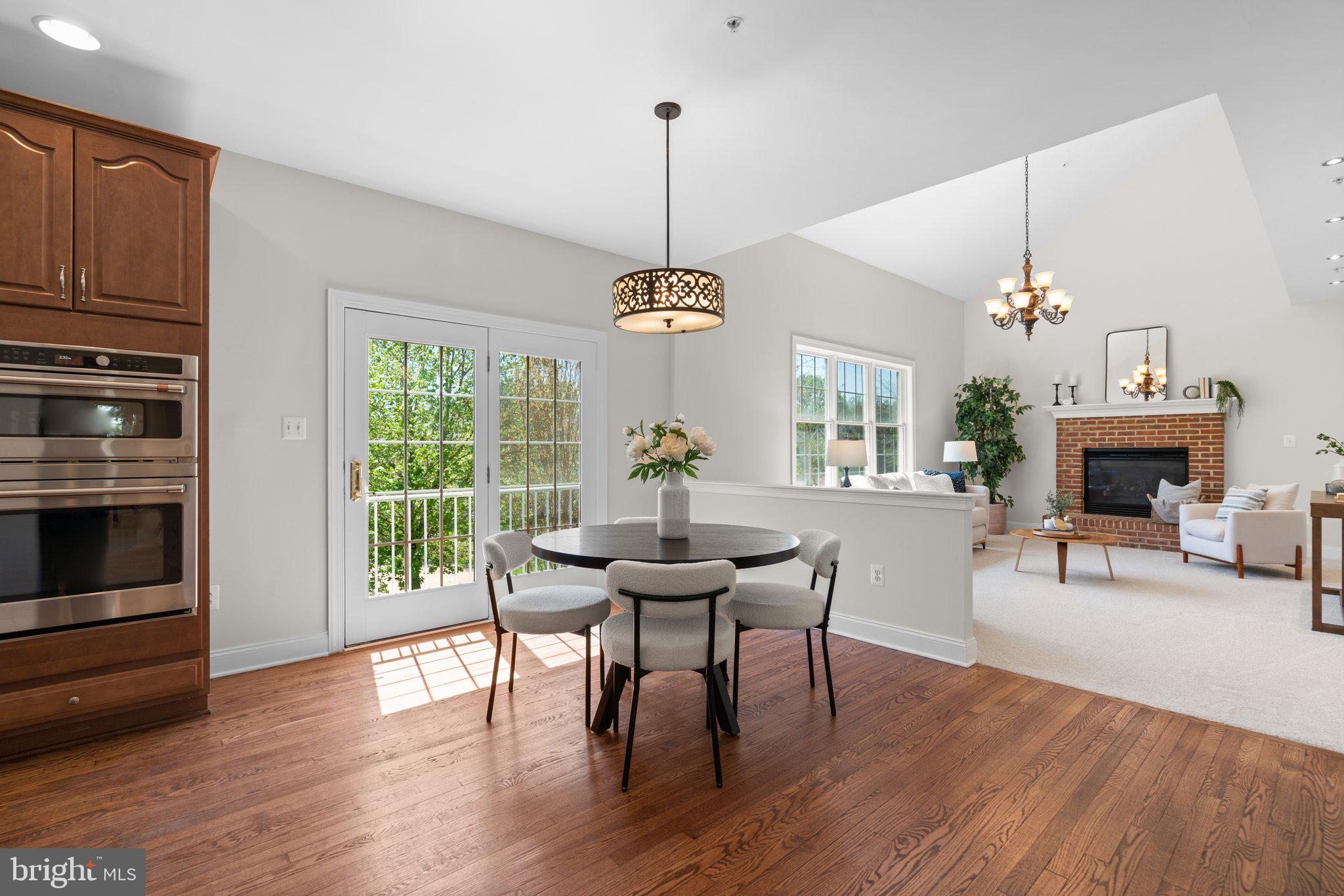 22104 Ginger Tree Way Clarksburg, MD 20871 - Photo 16 of 57 a dining room with furniture a chandelier and wooden floor