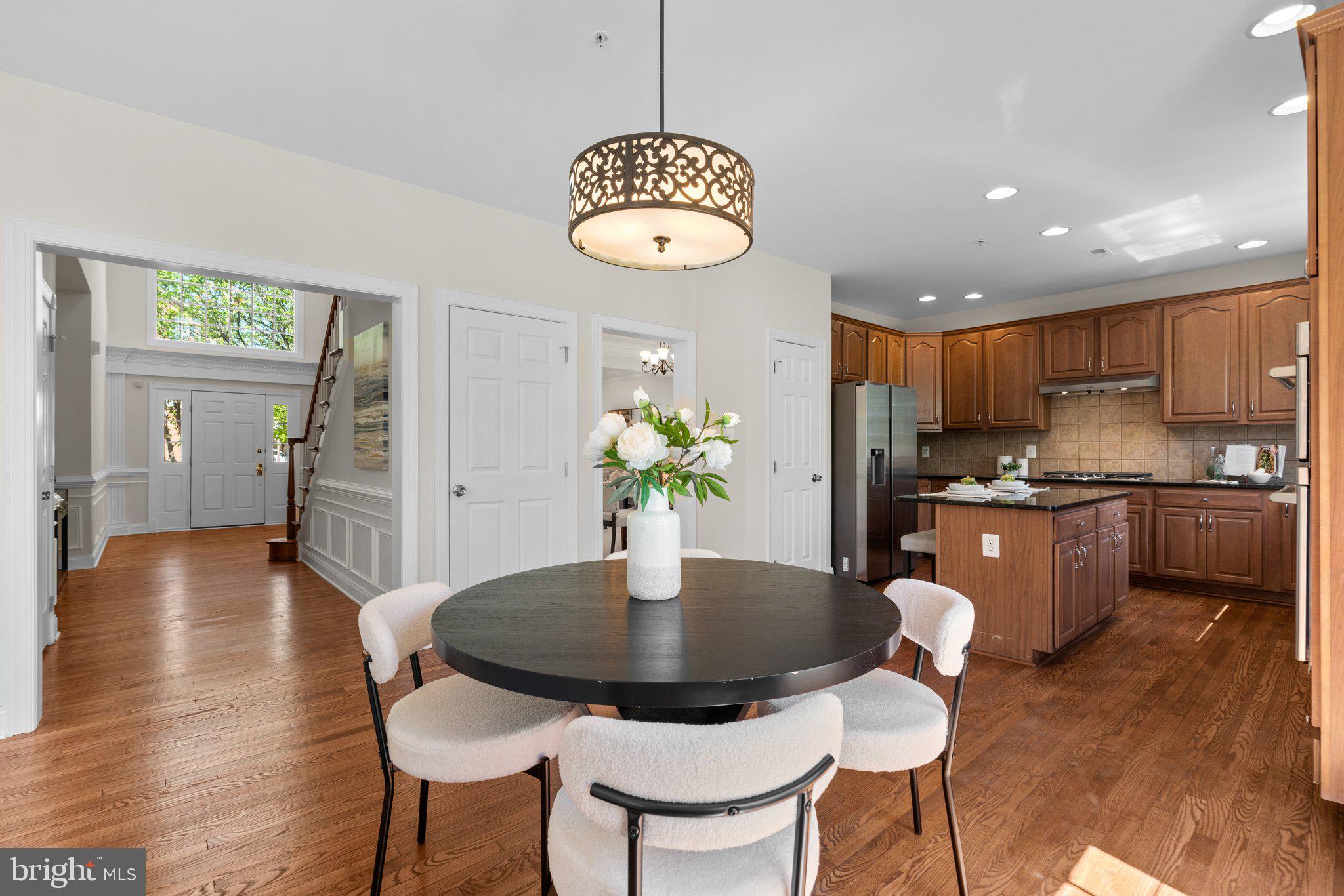 22104 Ginger Tree Way Clarksburg, MD 20871 - Photo 18 of 57 a kitchen with stainless steel appliances granite countertop a dining table chairs and chandelier