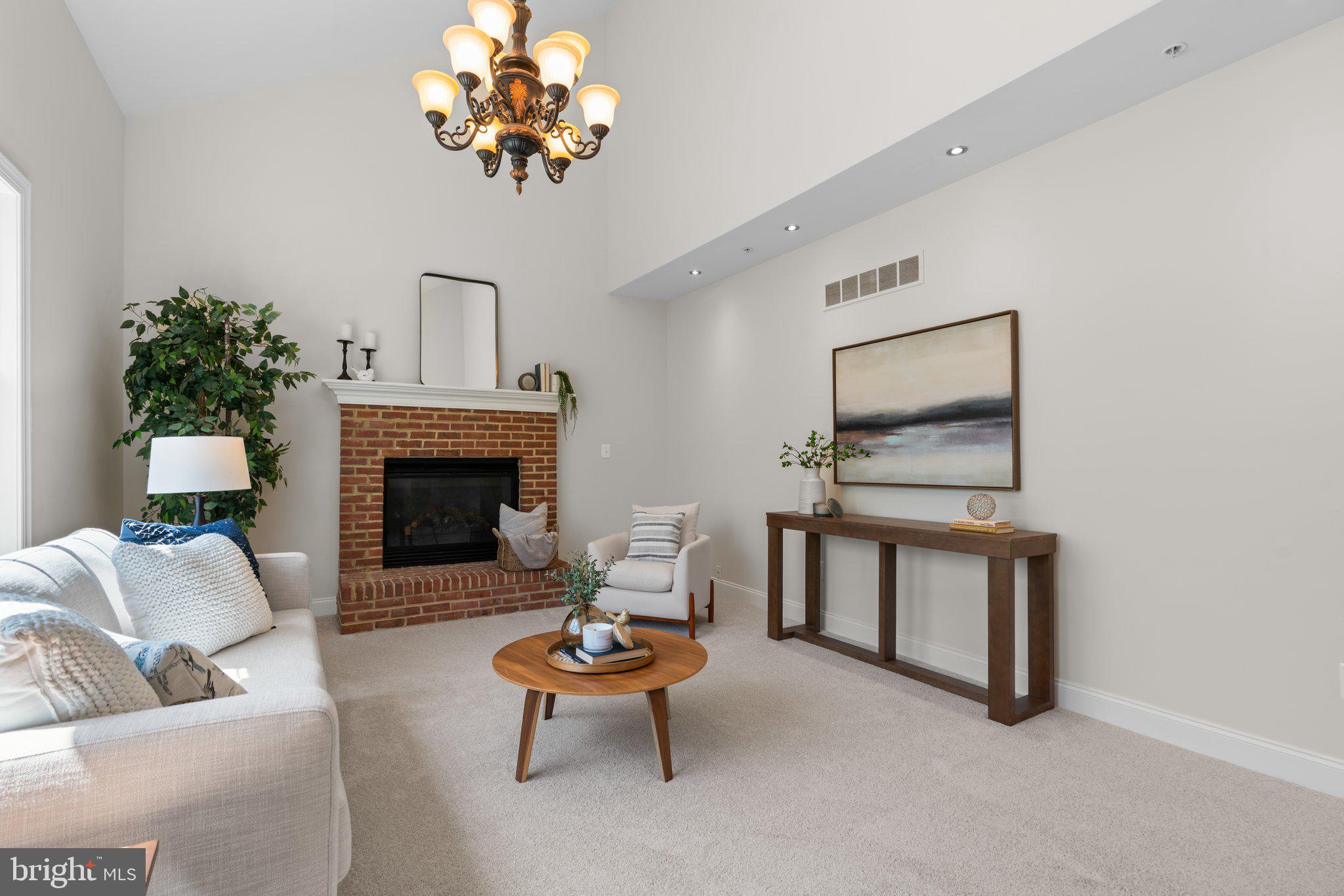 22104 Ginger Tree Way Clarksburg, MD 20871 - Photo 21 of 57 a living room with furniture a chandelier and a fireplace