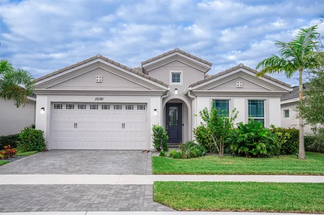 a front view of a house with a garden and plants