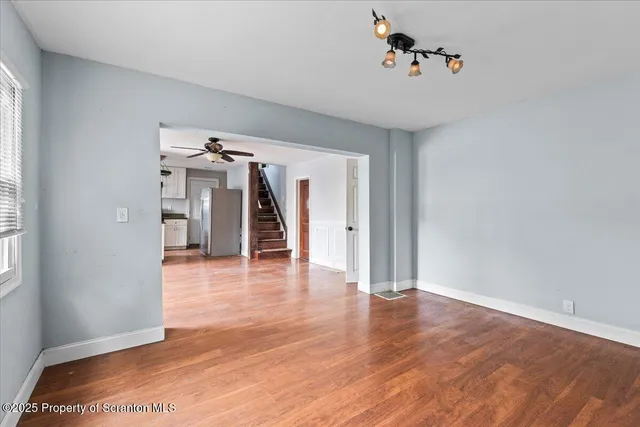 a view of a livingroom with wooden floor and a ceiling fan