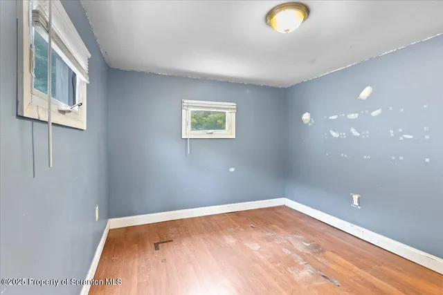 a view of a room with wooden floor and window