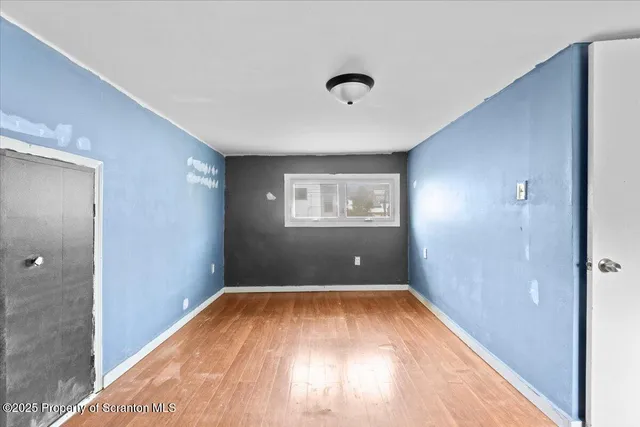 wooden floor in an empty room with a window
