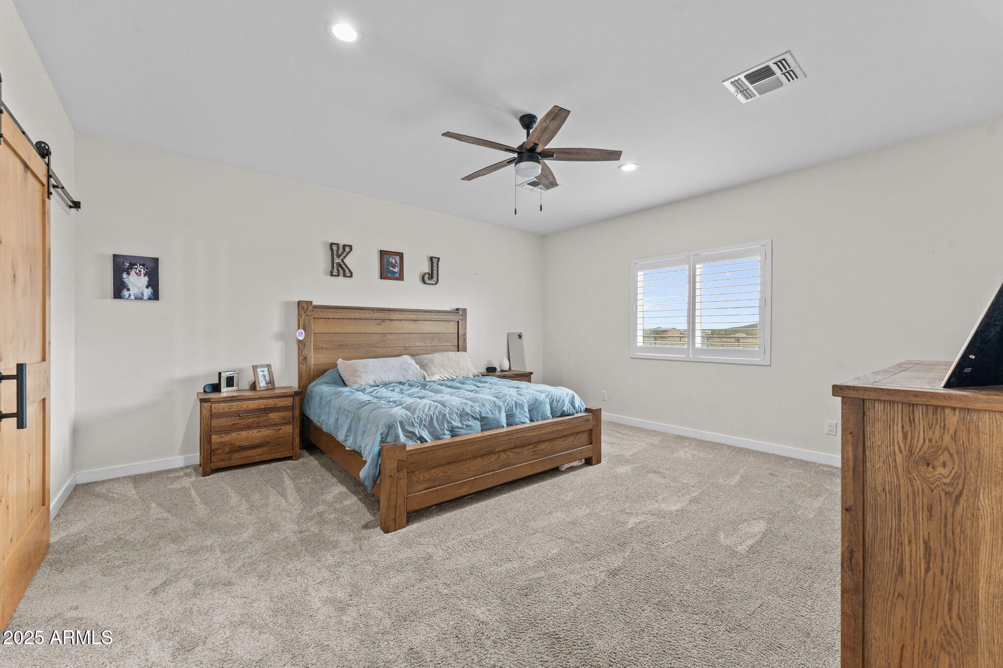 46130 West Trotter Road Wickenburg, AZ 85390 - Photo 18 of 55 a bedroom with a bed and a chandelier