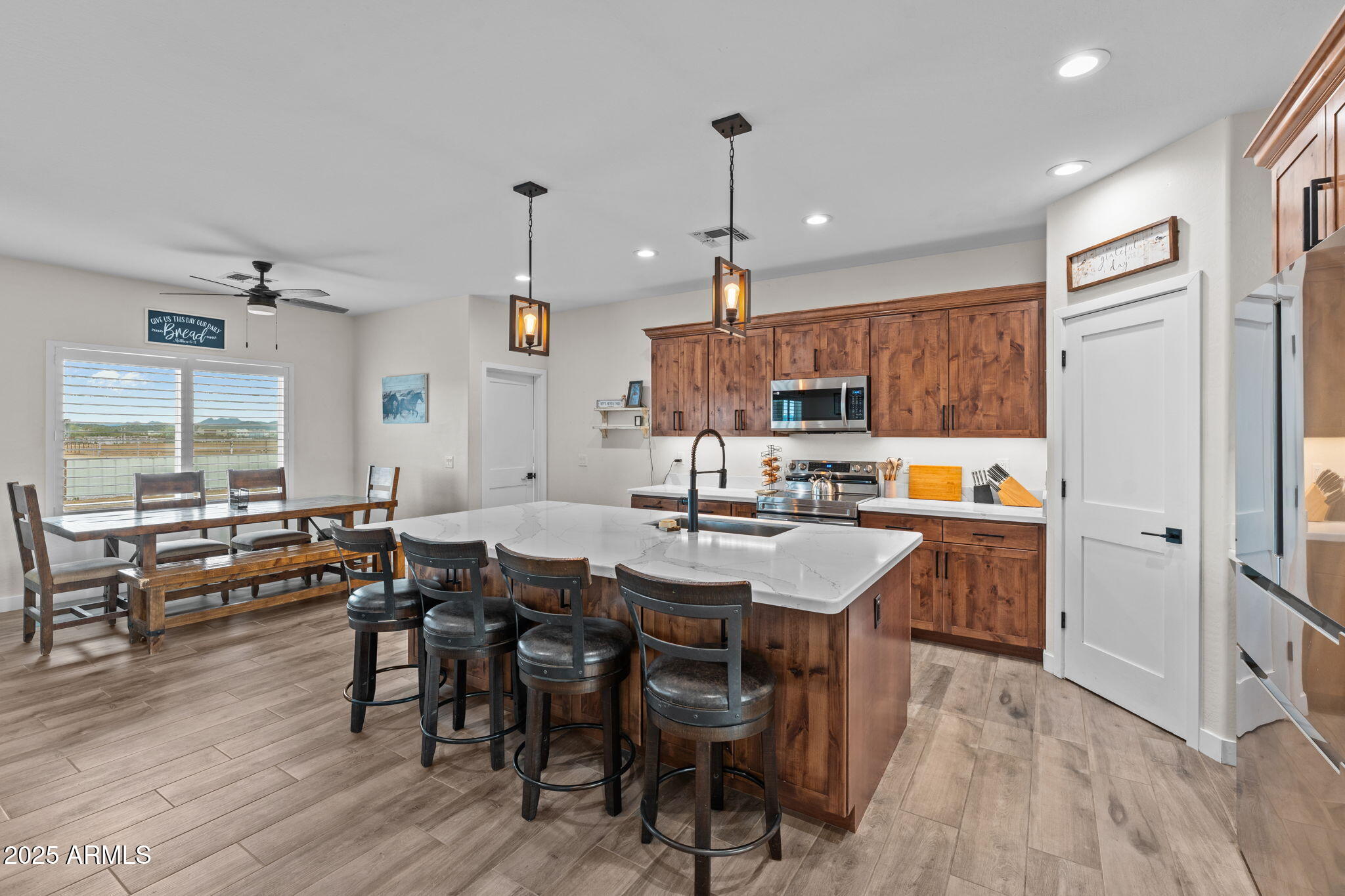 46130 West Trotter Road Wickenburg, AZ 85390 - Photo 7 of 55 a open dining room with stainless steel appliances kitchen island granite countertop a table chairs and a refrigerator