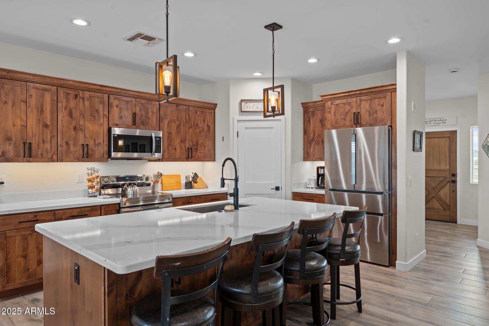 46130 West Trotter Road Wickenburg, AZ 85390 - Photo 9 of 55 a kitchen with granite countertop a table chairs stainless steel appliances and wooden floor