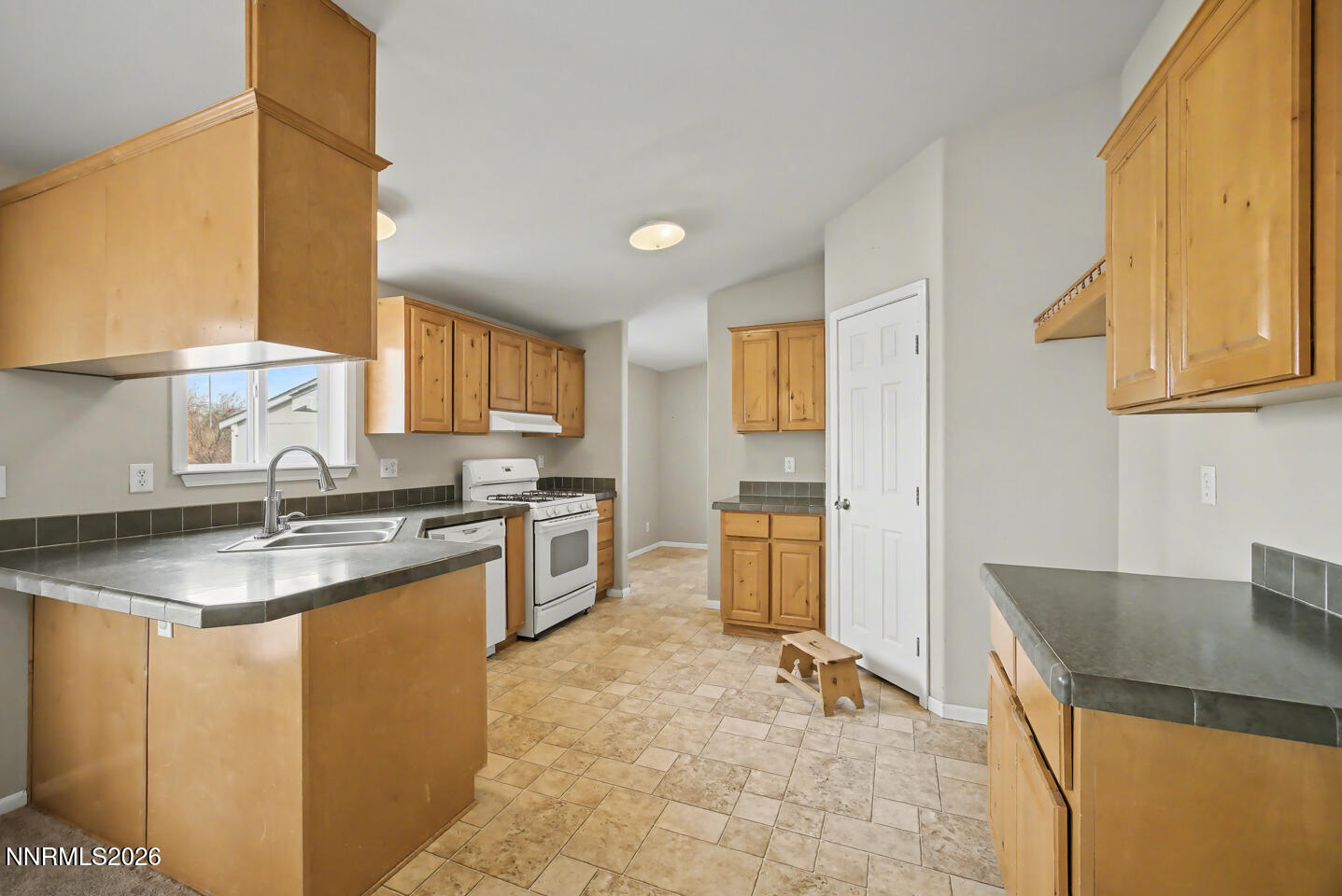 4141 Schindler Road Fallon, NV 89406 - Photo 10 of 25 a kitchen with granite countertop a sink stove and cabinets