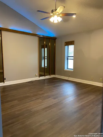 a view of an empty room with window and wooden floor