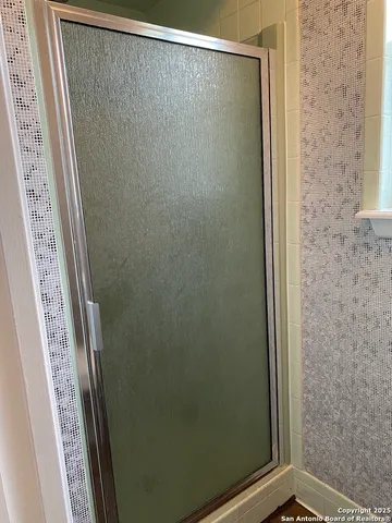 a bathroom with a glass shower door