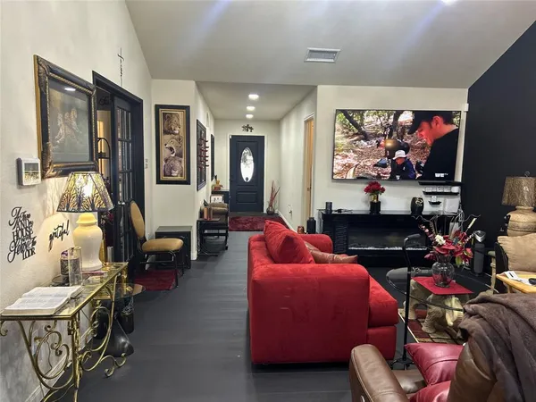 a living room with furniture a flat screen tv and a floor to ceiling window