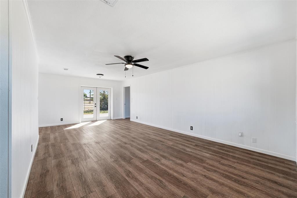 100 West Dilworth Road Italy, TX 76651 - Photo 14 of 38 a view of empty room with wooden floor and fan