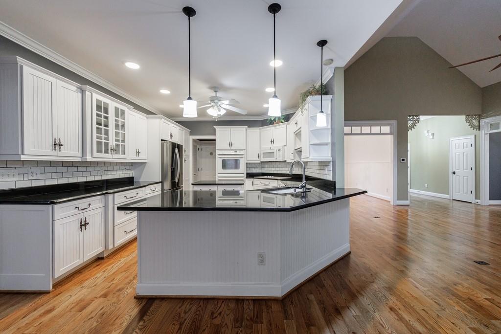 267 Sharp Mountain Parkway Jasper, GA 30143 - Photo 12 of 55 a kitchen with stainless steel appliances granite countertop a sink a stove and a wooden floor