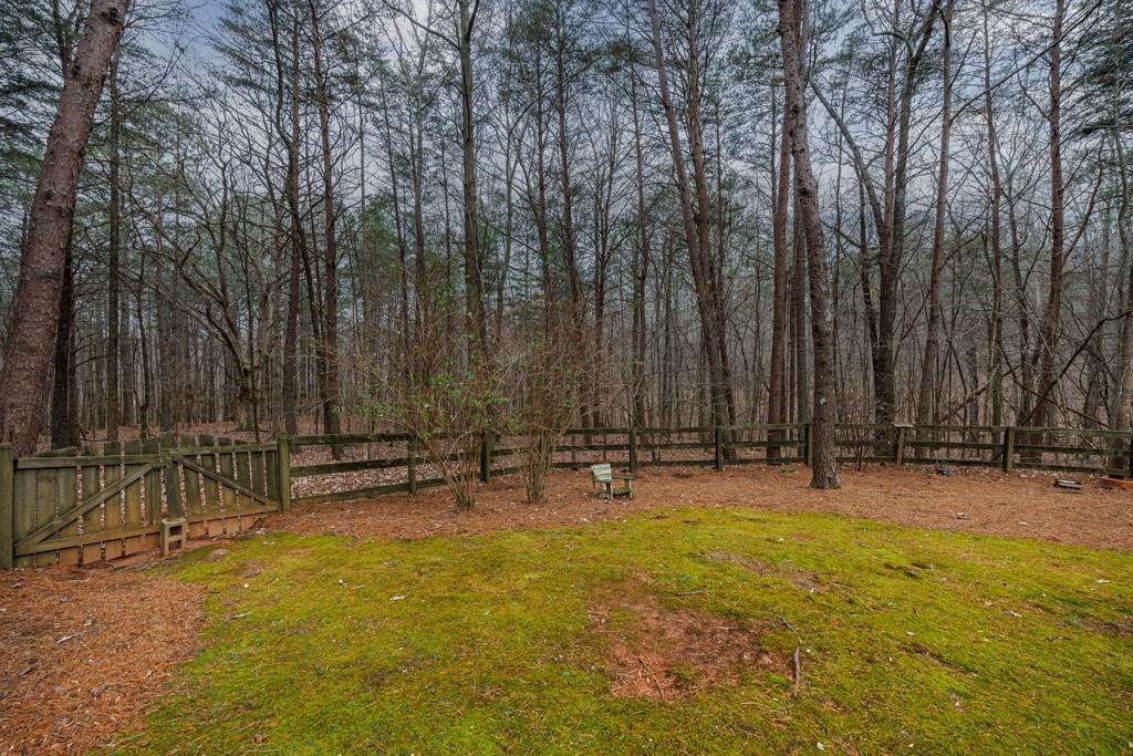 267 Sharp Mountain Parkway Jasper, GA 30143 - Photo 44 of 55 a backyard of a house with lawn chairs and wooden fence