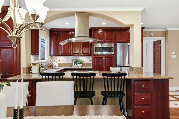 a bathroom with a granite countertop sink double mirror bathtub and toilet