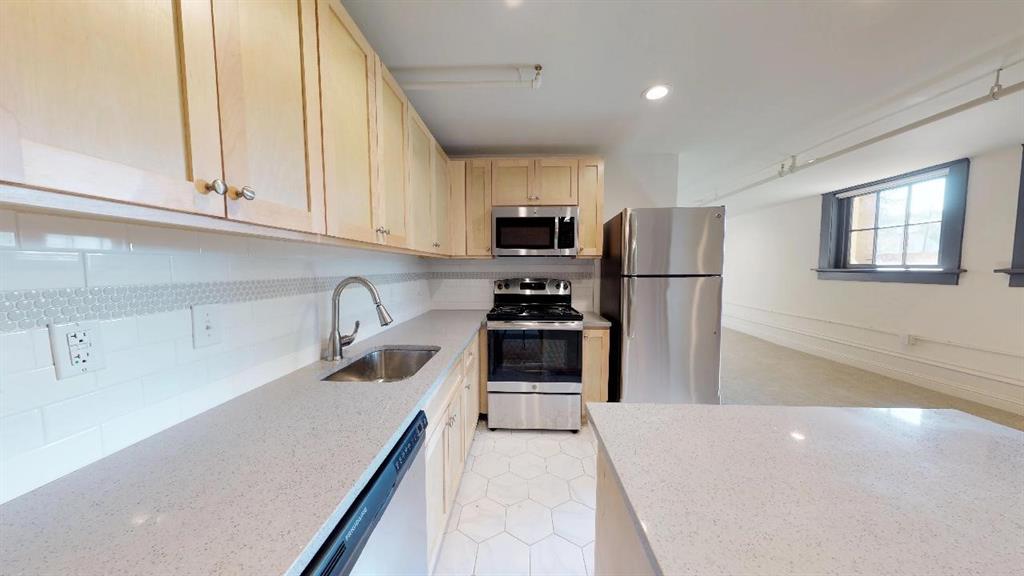 401 North Carroll Avenue, Unit 1208 Dallas, TX 75246 - Photo 5 of 5 a kitchen with a refrigerator a stove a sink a microwave and cabinets