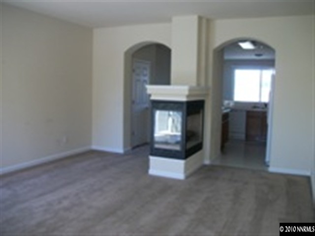415 Preston Burr Lane Reno, NV 89503 - Photo 3 of 9 an empty room with fireplace and fan