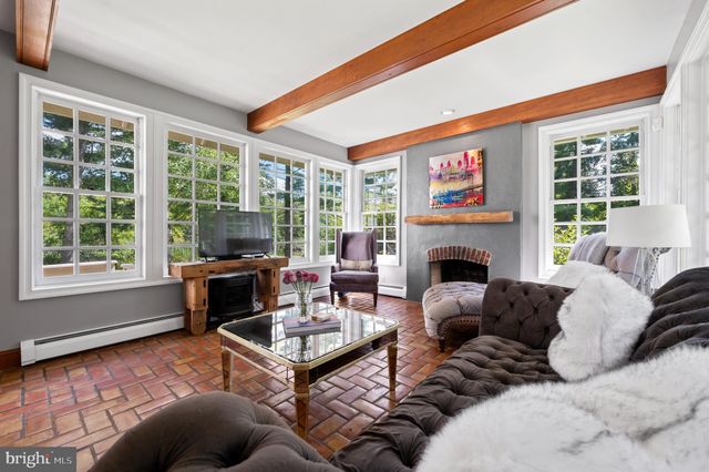 a living room with stainless steel appliances granite countertop furniture and a chandelier