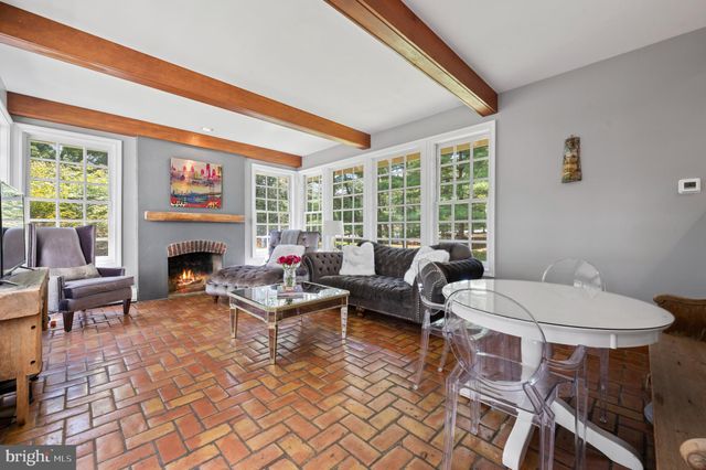 a living room with fireplace furniture and a large window