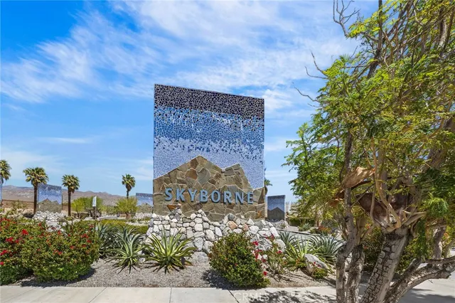 a view of a brick wall with plants and a bench