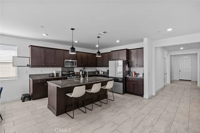 a kitchen with a sink a counter top space stainless steel appliances and cabinets