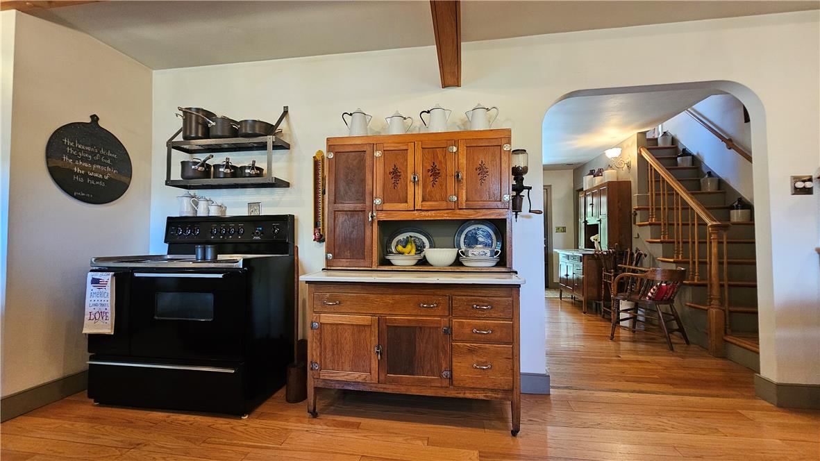 585 Buttermilk Road Hellertown, PA 18055 - Photo 12 of 82 Warm wood floors lead to a quaint kitchen space, connecting to a classic staircase.