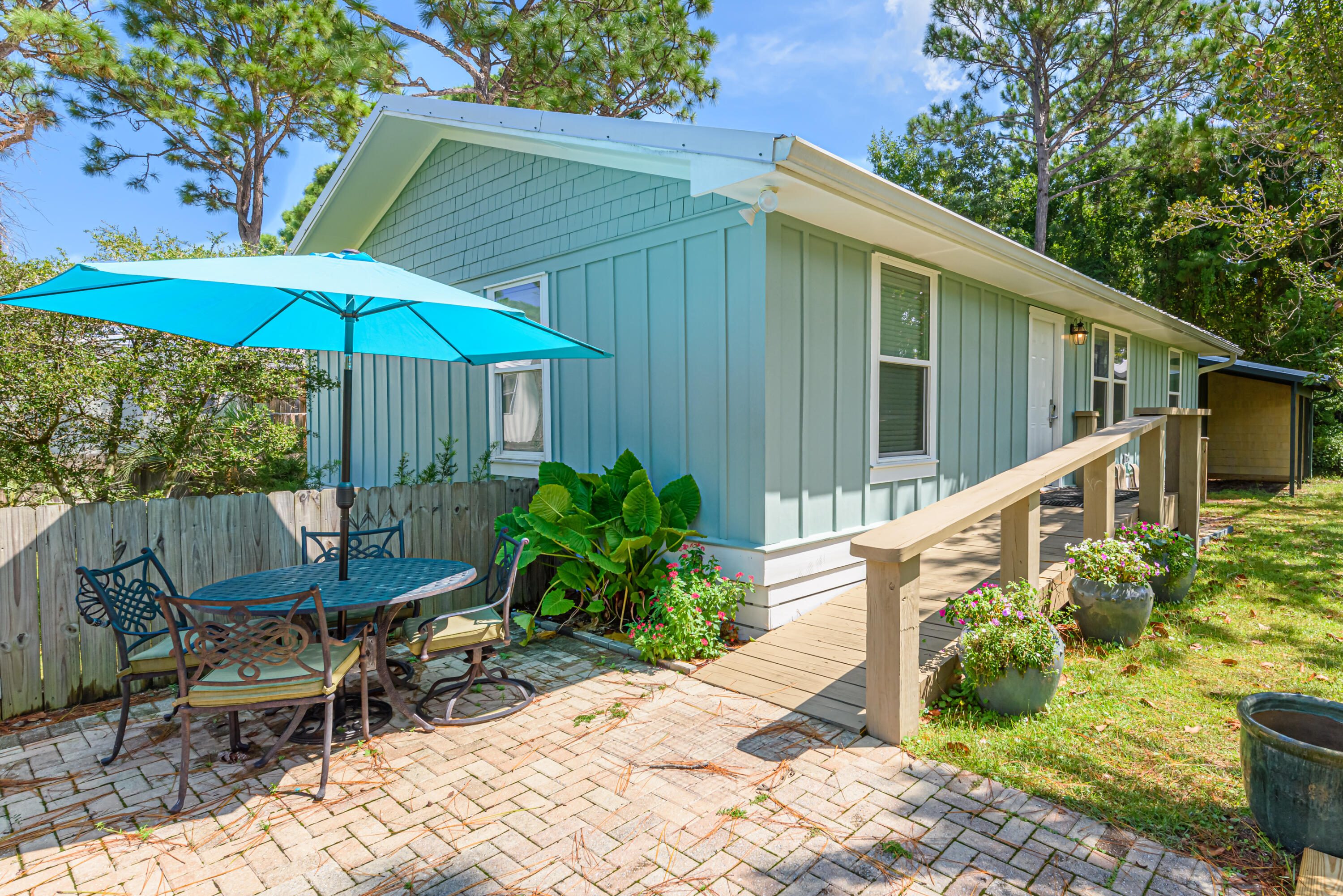 281 Elm Street Santa Rosa Beach, FL 32459 - Photo 3 of 37 a backyard of a house with table and chairs under an umbrella