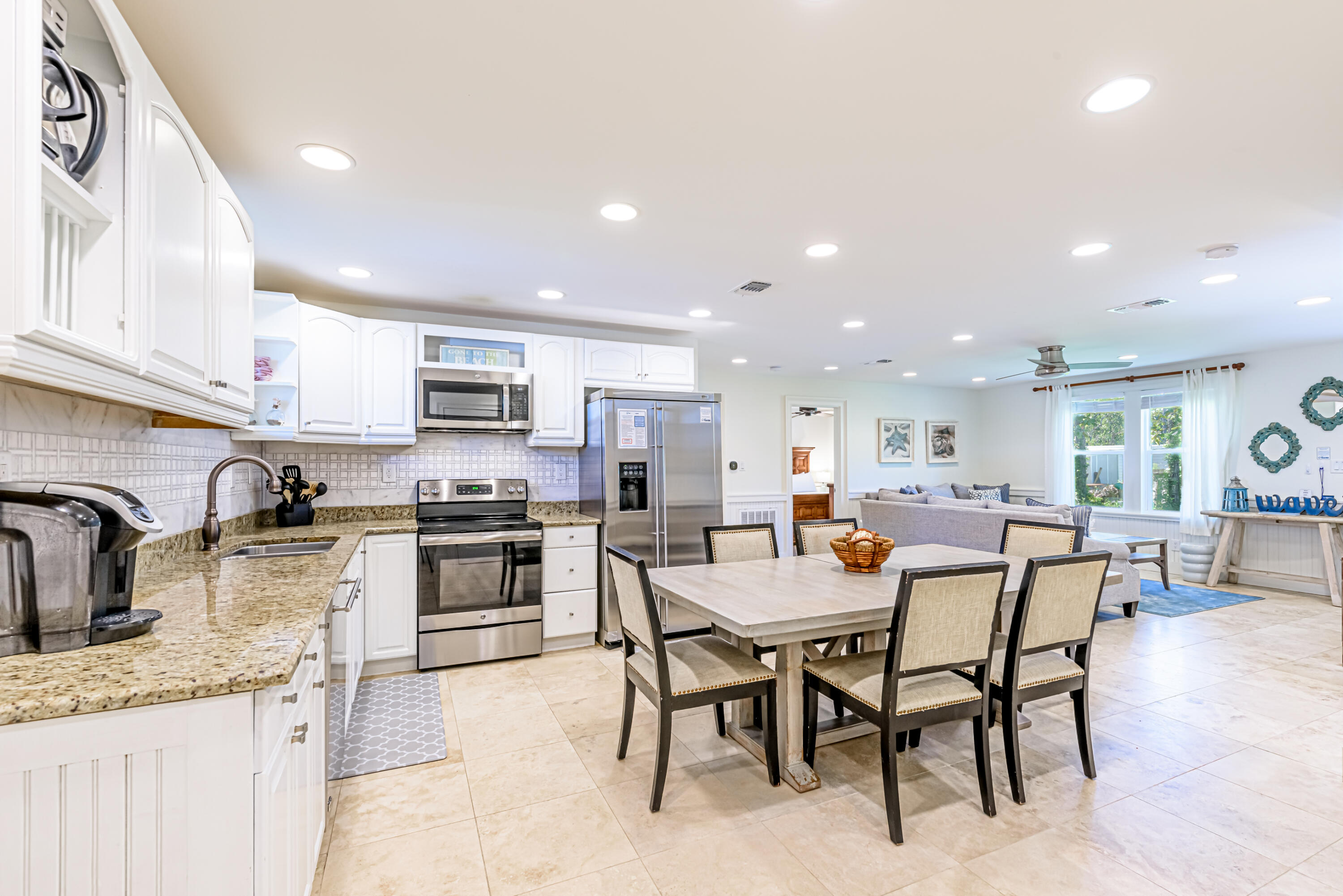 281 Elm Street Santa Rosa Beach, FL 32459 - Photo 7 of 37 a kitchen with stainless steel appliances kitchen island granite countertop a sink a stove a dining table and chairs