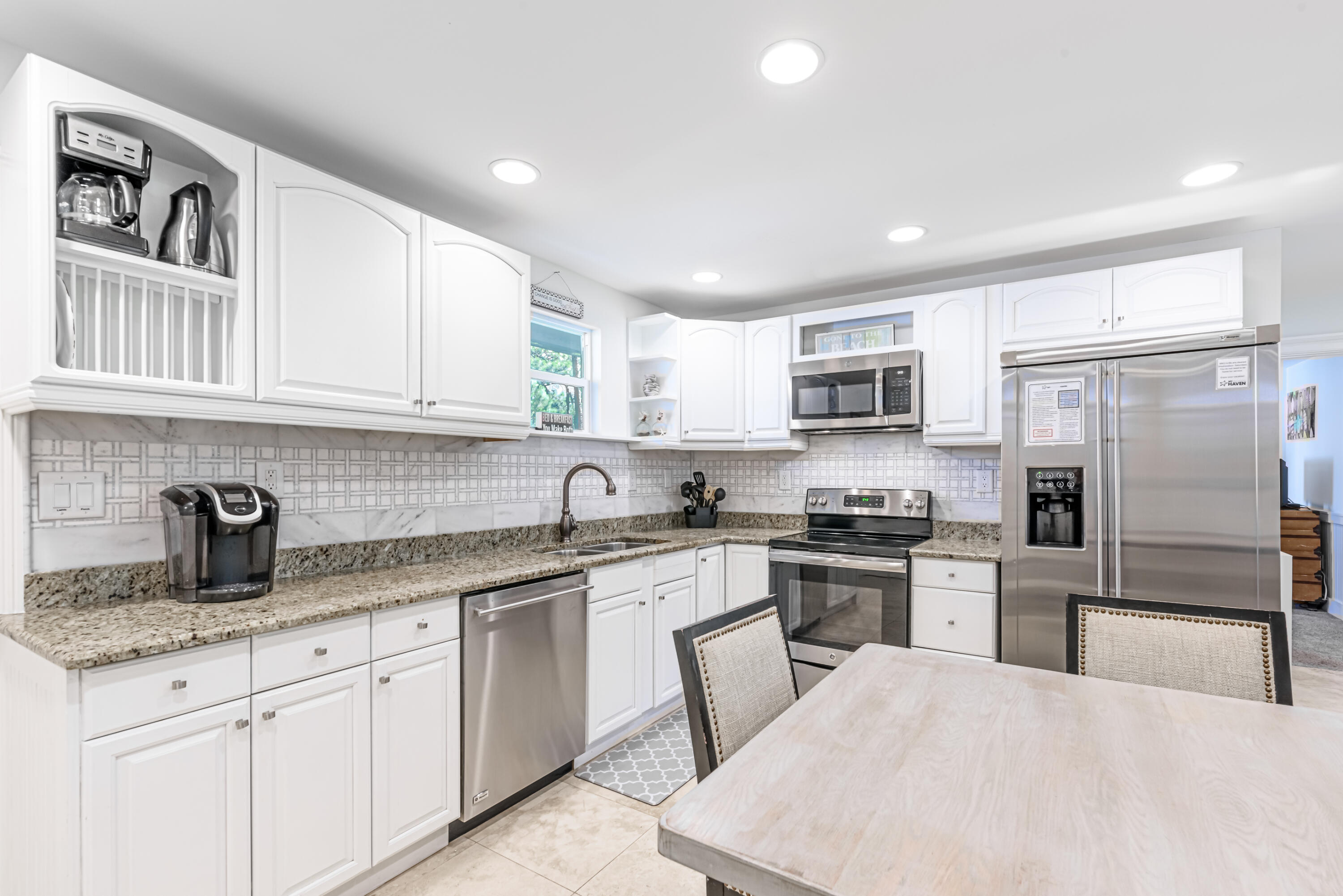 281 Elm Street Santa Rosa Beach, FL 32459 - Photo 8 of 37 a kitchen with white cabinets and stainless steel appliances