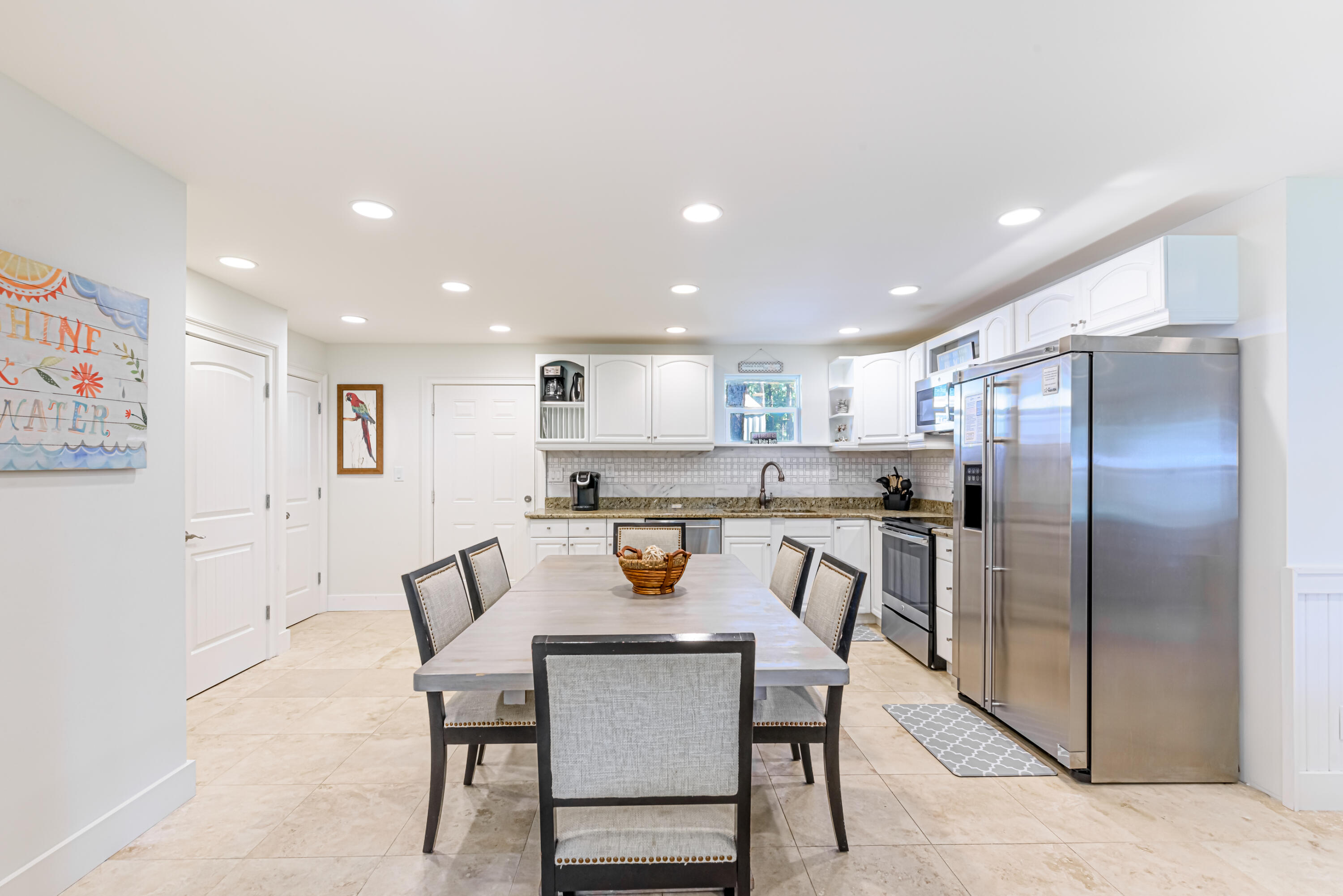 281 Elm Street Santa Rosa Beach, FL 32459 - Photo 9 of 37 a kitchen with a dining table chairs refrigerator and microwave