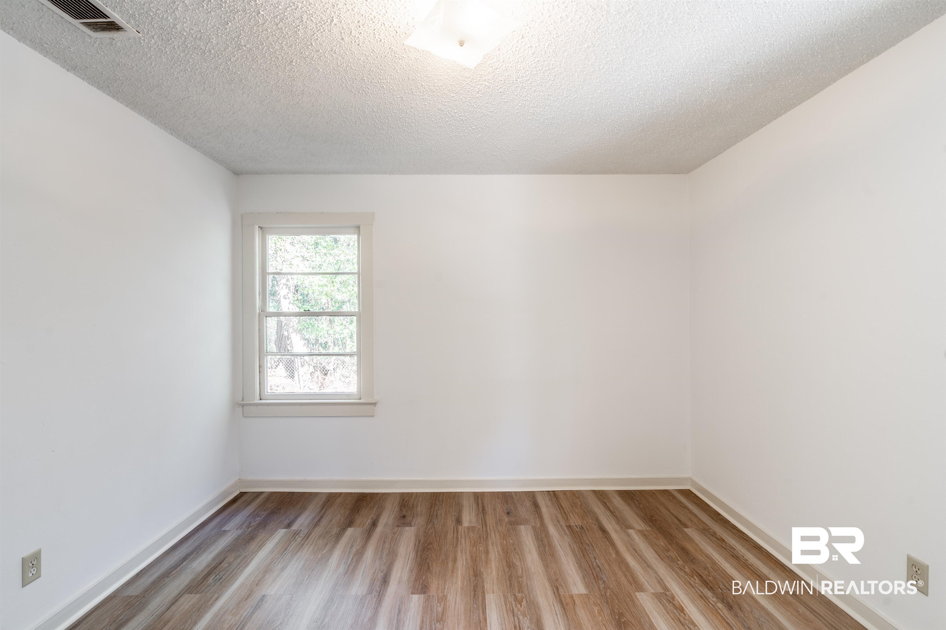 3900 Brookmont Drive Mobile, AL 36605 - Photo 13 of 19 Empty room with a textured ceiling and light hardwood / wood-style flooring