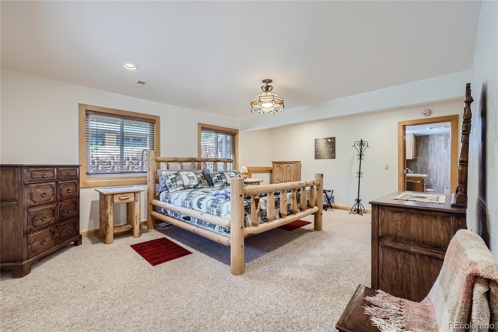 808 Conestoga Road Bailey, CO 80421 - Photo 24 of 50 a bedroom with a bed and a chandelier