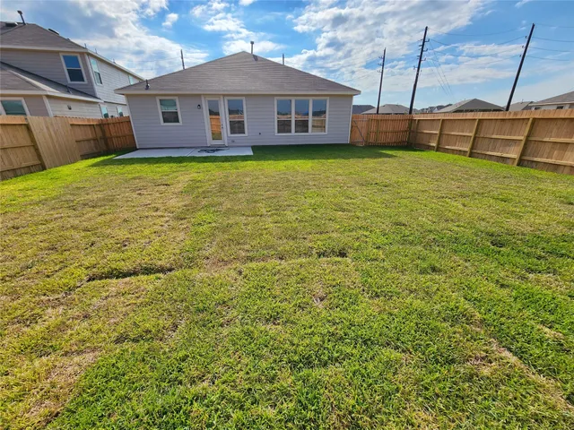 a view of a yard in front of a house with a large tree