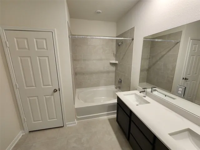 a bathroom with a double vanity sink a mirror and a bathtub