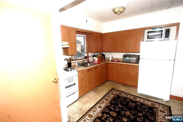 a kitchen with a sink a stove top oven and a refrigerator