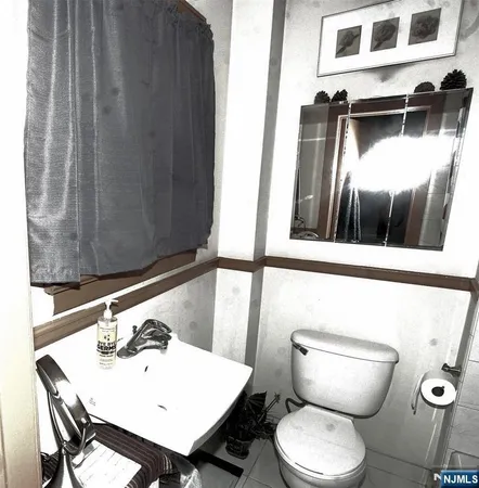 a bathroom with a toilet a sink and a mirror