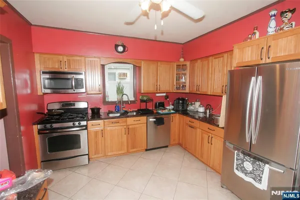 a kitchen with granite countertop a sink stainless steel appliances and cabinets