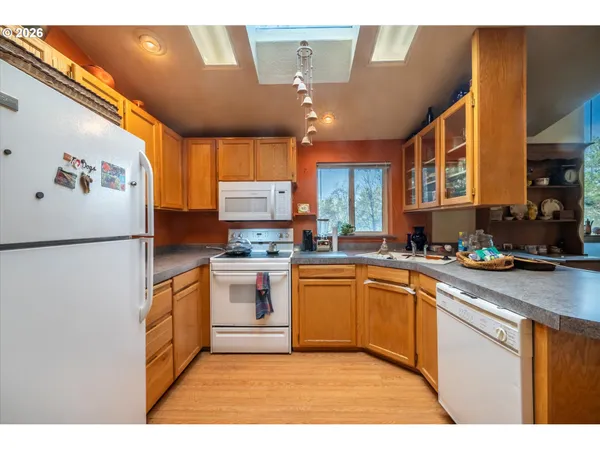 a kitchen with stainless steel appliances granite countertop a refrigerator a sink dishwasher a stove with wooden cabinets