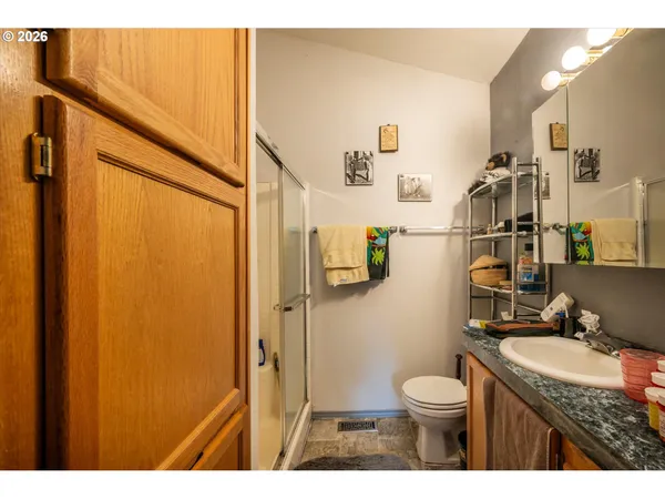 a bathroom with a granite countertop sink toilet and shower