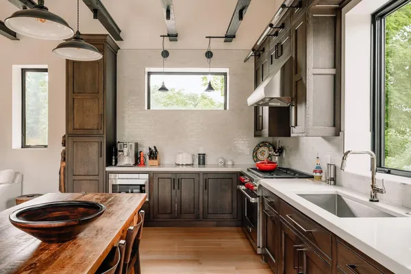 a kitchen that has a sink a stove and a wooden cabinets