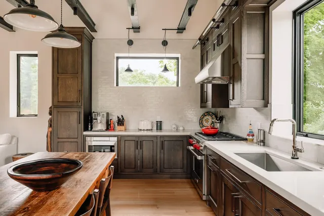 a kitchen that has a sink a stove and a wooden cabinets