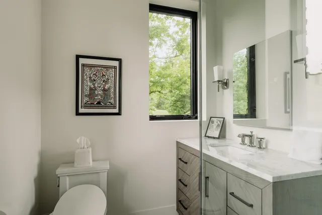 a bathroom with a toilet sink vanity and mirror