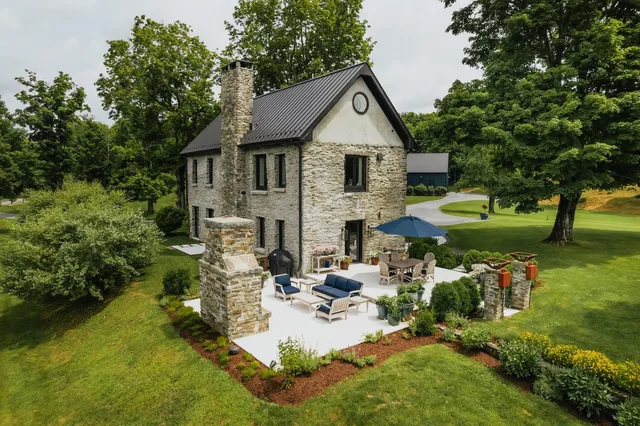 a view of a house with backyard and sitting area
