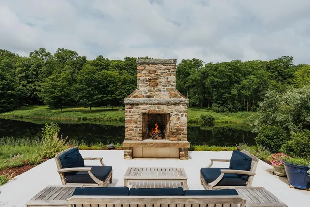 a view of a patio with couches table and chairs with wooden floor and a lake view