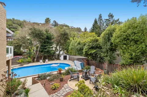 a front view of a house with a garden and tree