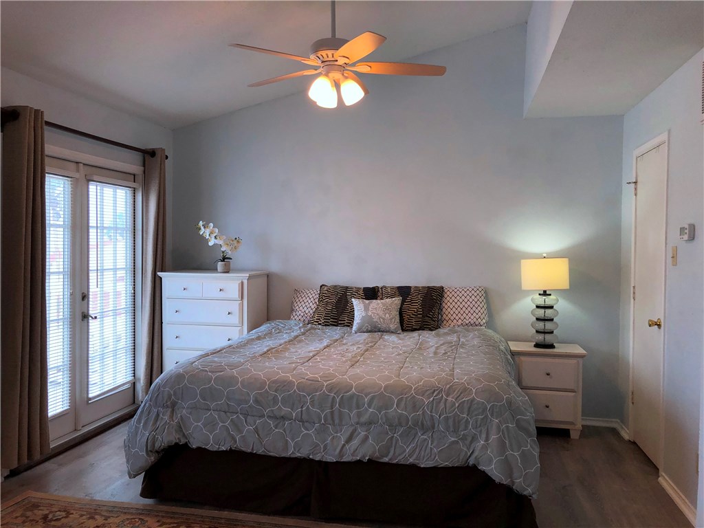 a bedroom with a bed and a chandelier fan