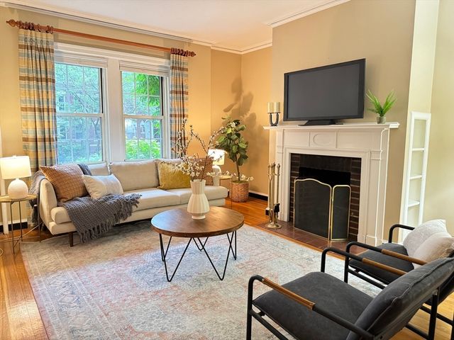 a living room with furniture a fireplace and a flat screen tv