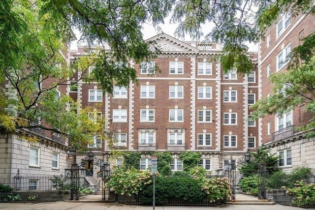 a front view of a multi story building with a yard