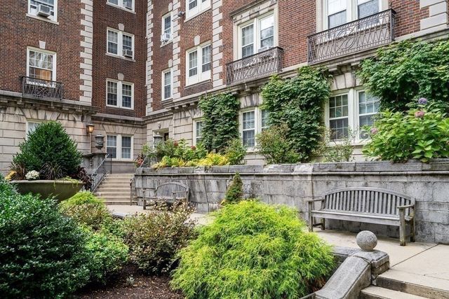 a view of a chair and table in the patio next to a building
