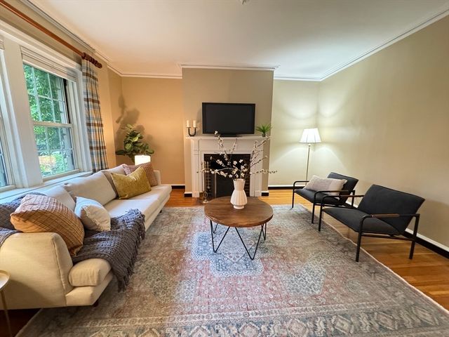 a living room with furniture a flat screen tv and a fireplace