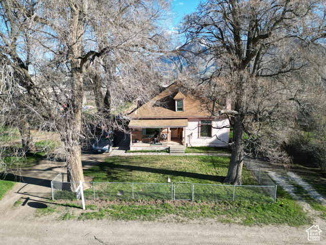View of front of house featuring a front yard, a fenced front yard, and dirt driveway